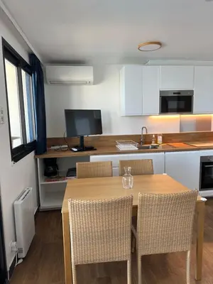 a kitchen with a table and chairs in a kitchen at Sisley 1061 - F2 Terrasse avec vue mer in Cannes