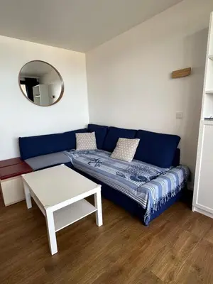 a living room with a blue couch and a table at Sisley 1061 - F2 Terrasse avec vue mer in Cannes