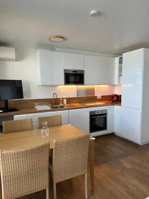a kitchen with a table and chairs and a kitchen with white cabinets at Sisley 1061 - F2 Terrasse avec vue mer in Cannes