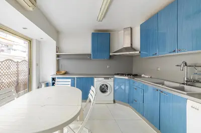 a kitchen with blue cabinets and a washing machine at Spacieux 3 chambres BALCON, MARTINEZ -CARLTON A3B130 in Cannes