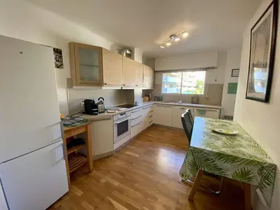 a small kitchen with a table and a table and a refrigerator at Cannes proche Croisette - 2P tout confort terrasse in Cannes