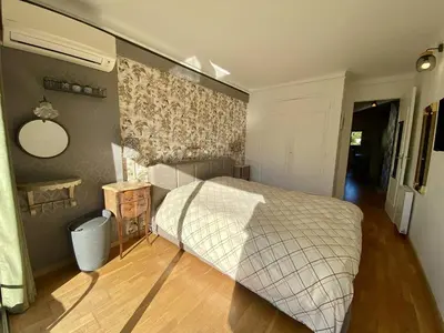 a bedroom with a bed and a mirror on the wall at Cannes proche Croisette - 2P tout confort terrasse in Cannes