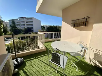 a patio with a table and chairs on a balcony at Cannes proche Croisette - 2P tout confort terrasse in Cannes