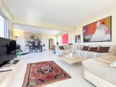 a living room with white furniture and a large painting on the wall at The Artist by Winsome Destination in Cannes