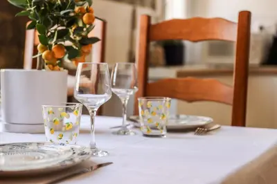 a table with three wine glasses and plates on it at La Dolce Vita T2 au calme plein coeur de Cannes in Cannes