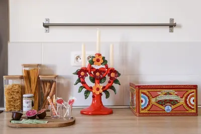 a red vase with a candle on a counter at La Dolce Vita T2 au calme plein coeur de Cannes in Cannes