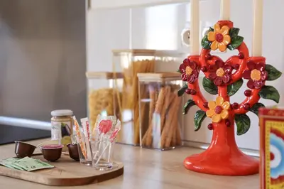 a red vase with flowers on a wooden table at La Dolce Vita T2 au calme plein coeur de Cannes in Cannes
