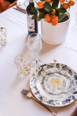 a table with a plate and a glass and a bottle of wine at La Dolce Vita T2 au calme plein coeur de Cannes in Cannes