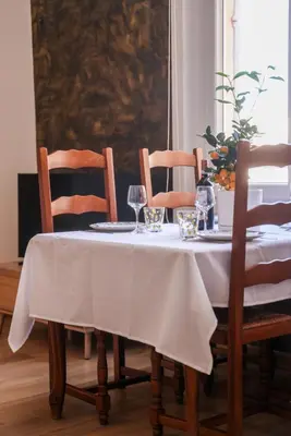 a table with a white table cloth on it with wine glasses at La Dolce Vita T2 au calme plein coeur de Cannes in Cannes