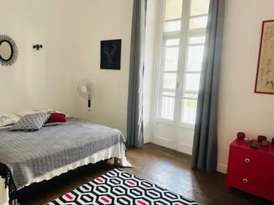 a bedroom with a bed and a large window at Appartement Roi Albert in Cannes
