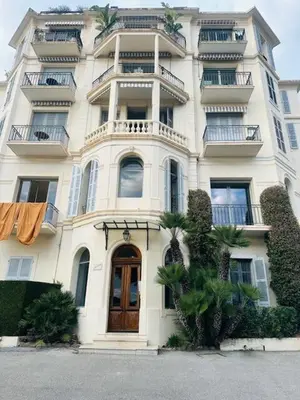 a large white building with balconies on top of it at Appartement Roi Albert in Cannes