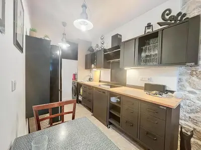 a kitchen with a table and a black refrigerator at À 1km Plage du Midi et Palais des Festivals - Appartement Centre Cannes avec Cour Extérieur Privée in Cannes