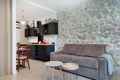a living room with a couch and a kitchen at À 1km Plage du Midi et Palais des Festivals - Appartement Centre Cannes avec Cour Extérieur Privée in Cannes