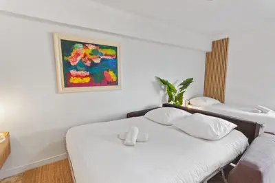 a white bedroom with a bed and a sink at Le Chambord - Hypercentre - Spacious - Terrace in Le Cannet