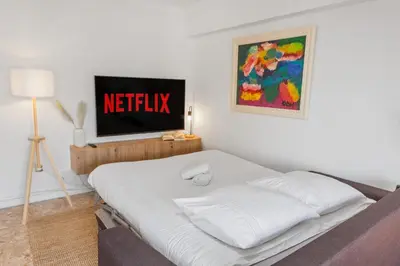 a bedroom with a bed with a television on the wall at Le Chambord - Hypercentre - Spacious - Terrace in Le Cannet