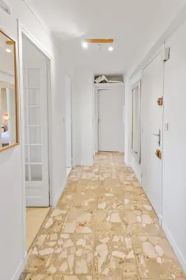 an empty hallway with white walls and a stone floor at Le Chambord - Hypercentre - Spacious - Terrace in Le Cannet