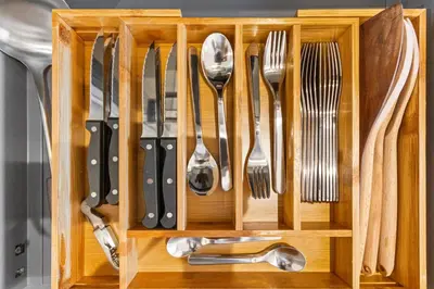 a wooden drawer with utensils in it at Le Chambord - Hypercentre - Spacious - Terrace in Le Cannet