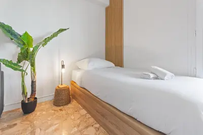 a bedroom with two beds and a potted plant at Le Chambord - Hypercentre - Spacious - Terrace in Le Cannet