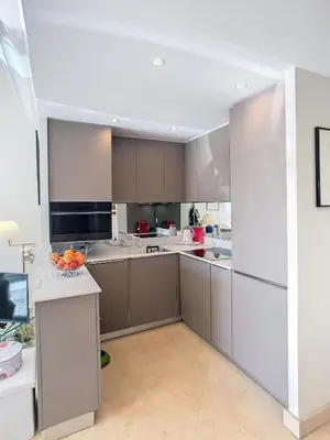a large kitchen with white cabinets and a counter at Emplacement idéal, terrasse vue mer 321L SEB in Cannes