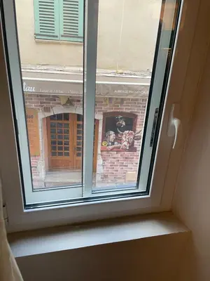 a window with a view of a brick building at Cannes historic center in Cannes