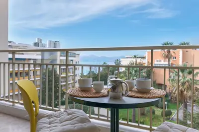 a table on a balcony with a view of the ocean at Terrasse de Timily - Vue mer, plage, clim, parking in Cannes