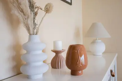 three white vases sitting on a table with a lamp at Terrasse de Timily - Vue mer, plage, clim, parking in Cannes