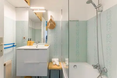 a bathroom with a tub and a sink and a shower at Terrasse de Timily - Vue mer, plage, clim, parking in Cannes
