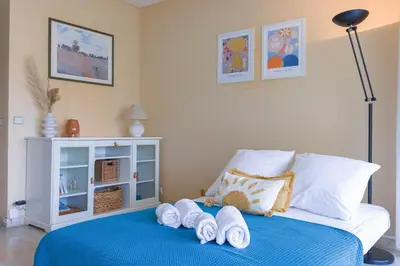 a bedroom with a bed with towels on it at Terrasse de Timily - Vue mer, plage, clim, parking in Cannes