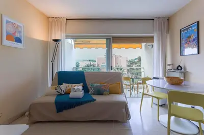 a living room with a couch and a table at Terrasse de Timily - Vue mer, plage, clim, parking in Cannes