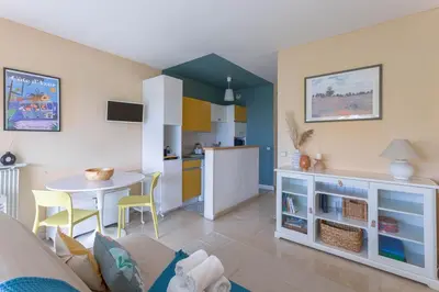 a living room with a table and a kitchen at Terrasse de Timily - Vue mer, plage, clim, parking in Cannes