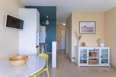 a kitchen and dining room with a table and chairs at Terrasse de Timily - Vue mer, plage, clim, parking in Cannes