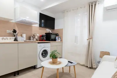 a kitchen with a washing machine and a table at L’Espérance dAzur - 500 m de la plage in Cannes