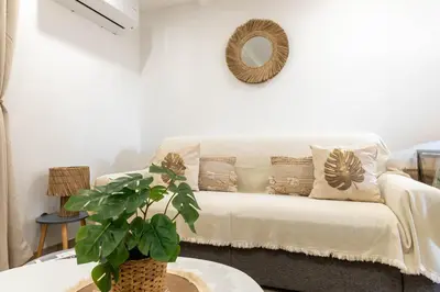 a white couch in a living room with a plant at L’Espérance dAzur - 500 m de la plage in Cannes