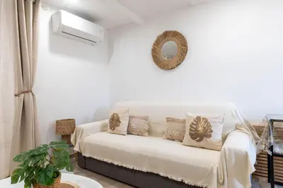 a white living room with a couch and a mirror at L’Espérance dAzur - 500 m de la plage in Cannes