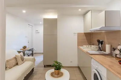 a kitchen and living room with a couch and a table at L’Espérance dAzur - 500 m de la plage in Cannes