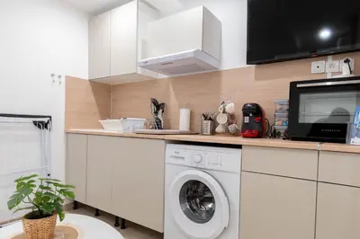 a kitchen with a washing machine and a tv at L’Espérance dAzur - 500 m de la plage in Cannes