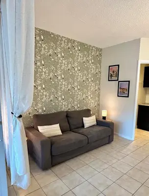 a living room with a brown couch in front of a wall at Cosy studio near La Croisette and the beach in Cannes