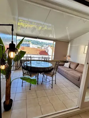 a living room with a table and a couch at Cosy studio near La Croisette and the beach in Cannes