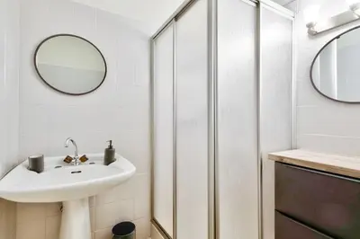 a white bathroom with a sink and a shower at Cosy studio near La Croisette and the beach in Cannes