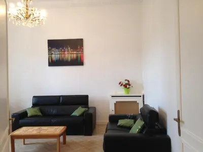 a living room with a black couch and a table at Winter Palace in Cannes