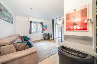 a living room with a couch and a tv at Studio au calme dans le quartier du Suquet - Proche Croisette et centre-ville in Cannes