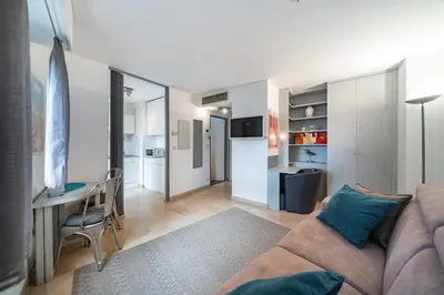 a living room with a couch and a table and a desk at Studio au calme dans le quartier du Suquet - Proche Croisette et centre-ville in Cannes