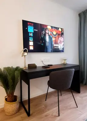 a black desk with a chair and a tv on the wall at Cozy studio in the heart of Cannes in Cannes