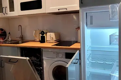 a kitchen with a washing machine in a kitchen at Cozy studio in the heart of Cannes in Cannes