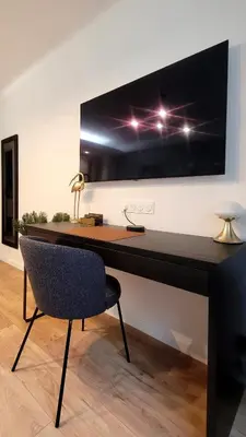 a desk with a chair and a television on a wall at Cozy studio in the heart of Cannes in Cannes