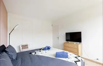 a bedroom with a bed and a sink and a television at Appartement spacieux avec vue au Cannet 114 m² in Le Cannet