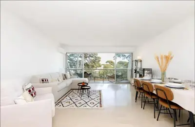 a living room with a white couch and a table at Appartement spacieux avec vue au Cannet 114 m² in Le Cannet