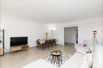 a white living room with a white couch and a table at Appartement spacieux avec vue au Cannet 114 m² in Le Cannet