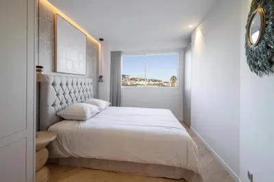 a white bedroom with a large bed and a window at REF 2012 - Cannes Croisette - Apartment to rent sea view in Cannes