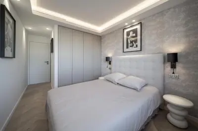 a bedroom with a large white bed and a table at REF 2012 - Cannes Croisette - Apartment to rent sea view in Cannes